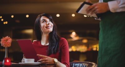Waiter taking order from woman in a restaurant sms gateway